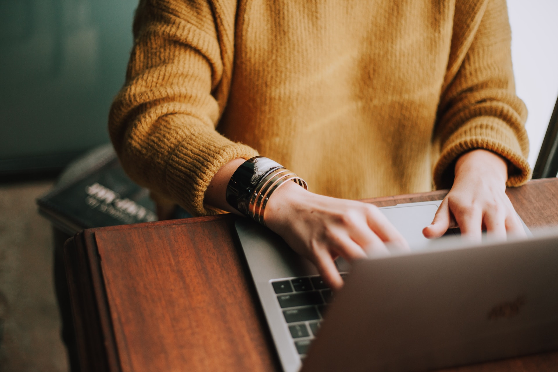 a person using a laptop computer on a wooden desk